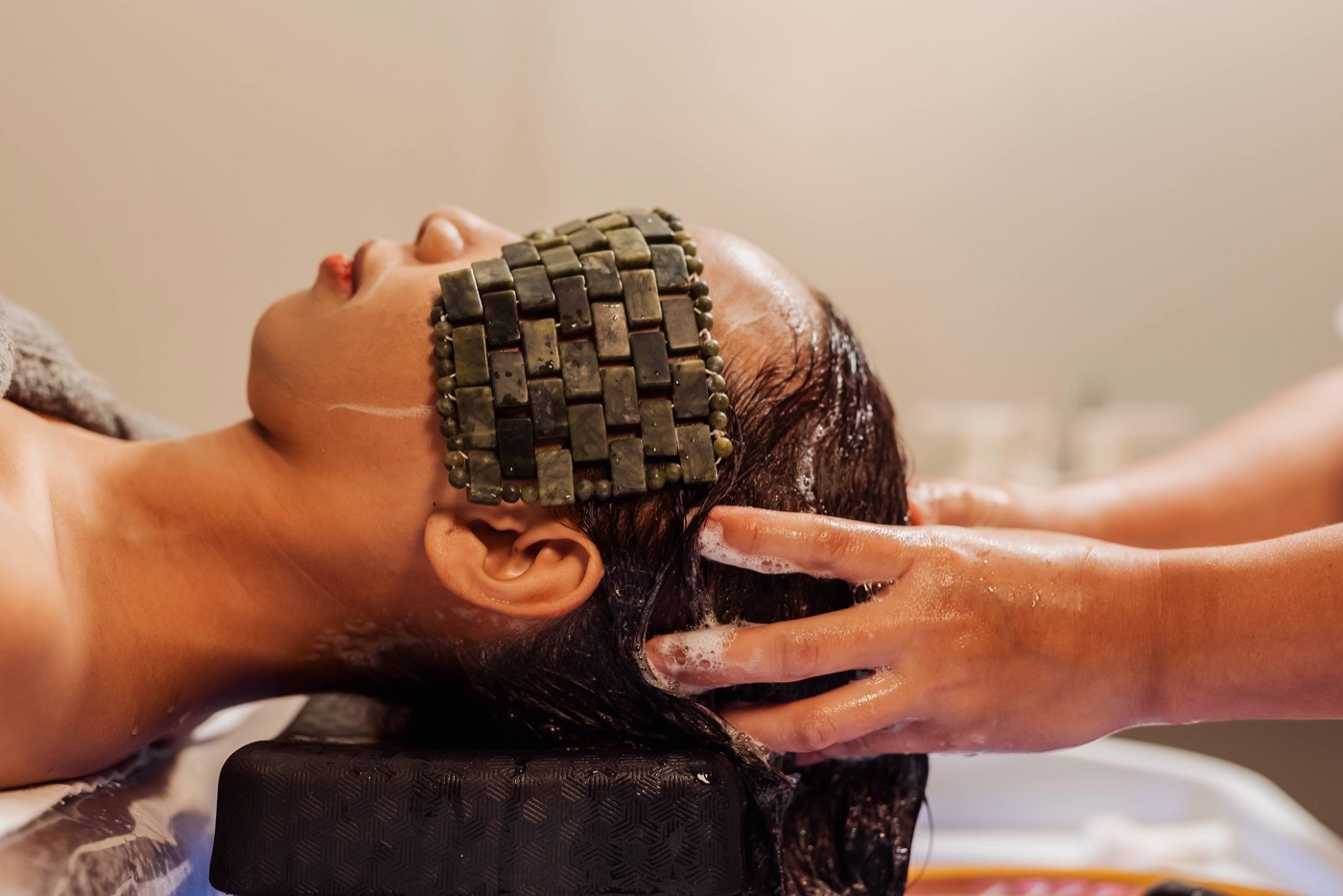 Guest receiving a jade eyemask head spa treatment