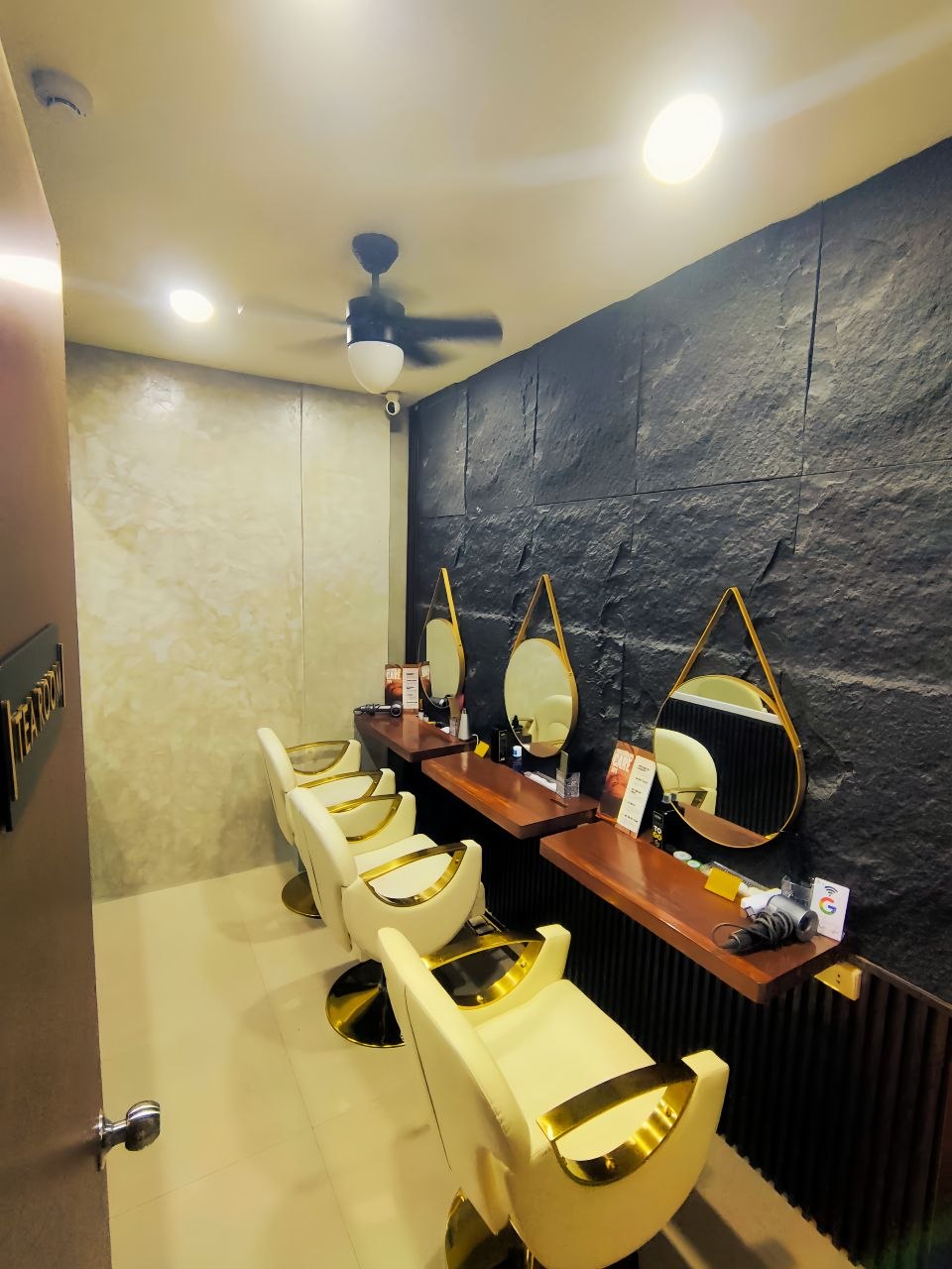 Styling station with black stone wall and round mirrors