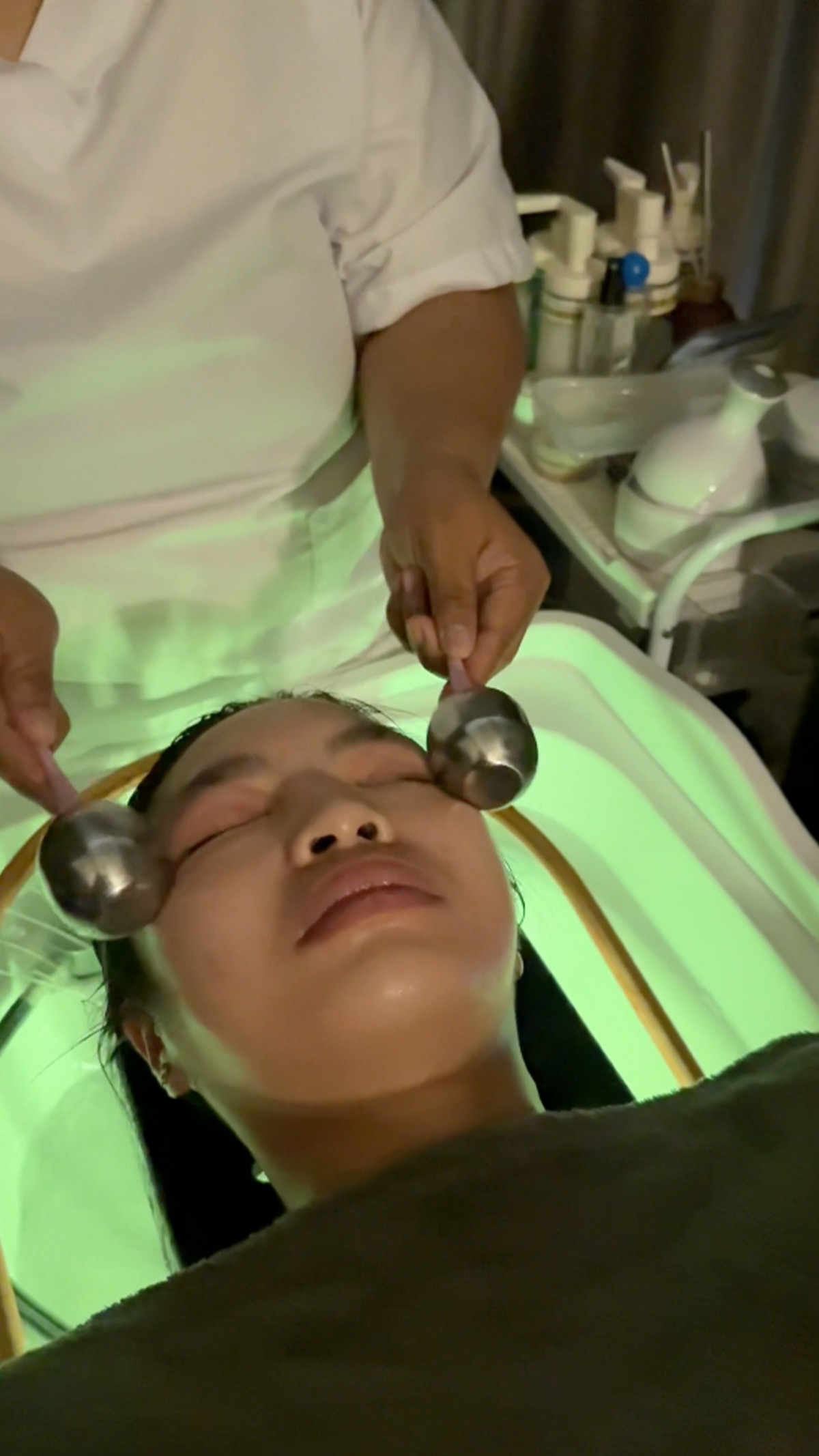 Cooling roller facial treatment under green light