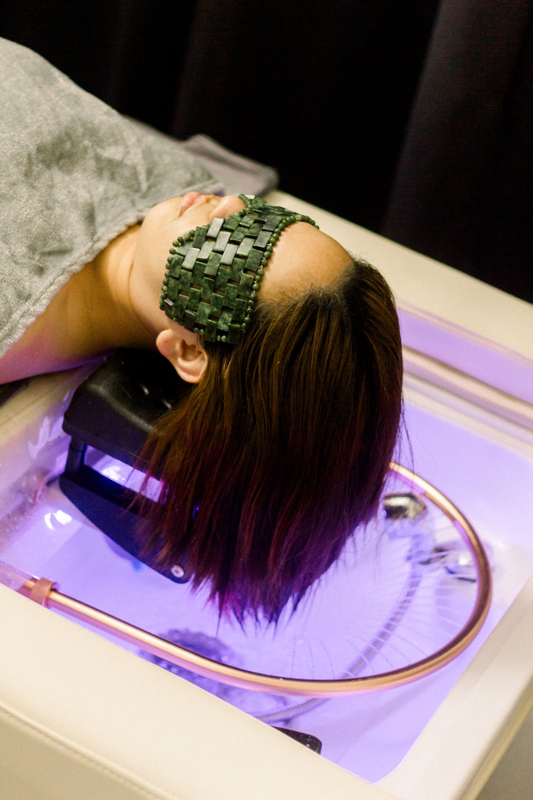 Guest relaxing with a jade head massage tool